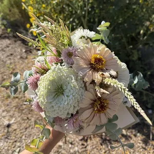 A medium bouquet of seasonal flowers wrapped with paper.